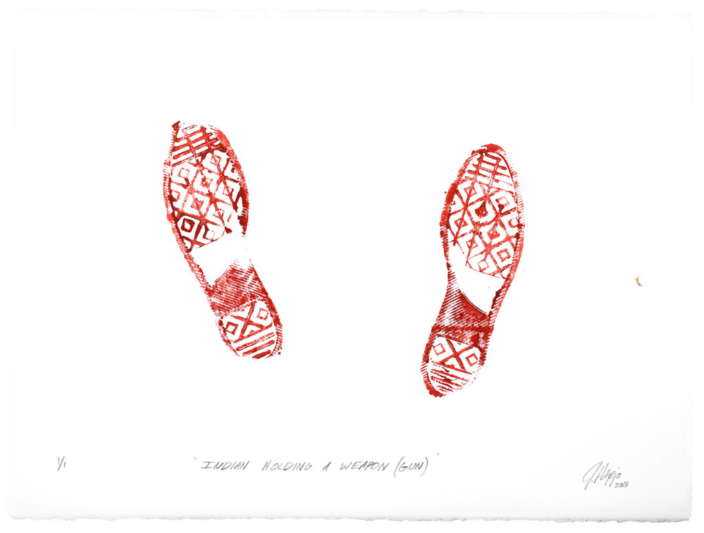 On creamwhite paper, in brightred ink, the imprint of footwear with a complex tread, made up of voided lozenges under the sole and heel, horizontal bars at the toe and end of the heel, and an oblique block under the arch beginning at the heel and ascending to the instep halfway up. Vertical bars transverse the voided lozenges along the sole, bisecting them. Both feet are splayed slightly outward, and that on the left is placed slightly ahead, and angled outward slightly more than that on the right. The inner tip of the toe of the left foot has not made contact with the paper, nor that the outer edge of the heel of the right. Beneath, in blackinked oblique print hand, "INDIAN HOLDING A WEAPON (GUN)", and in the bottom right corner, the cursive signature J Harjo 2018", where the data is in subscript. 